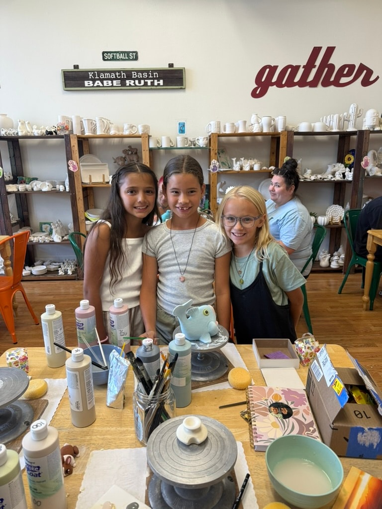 Three girls posing at pottery studio workshop