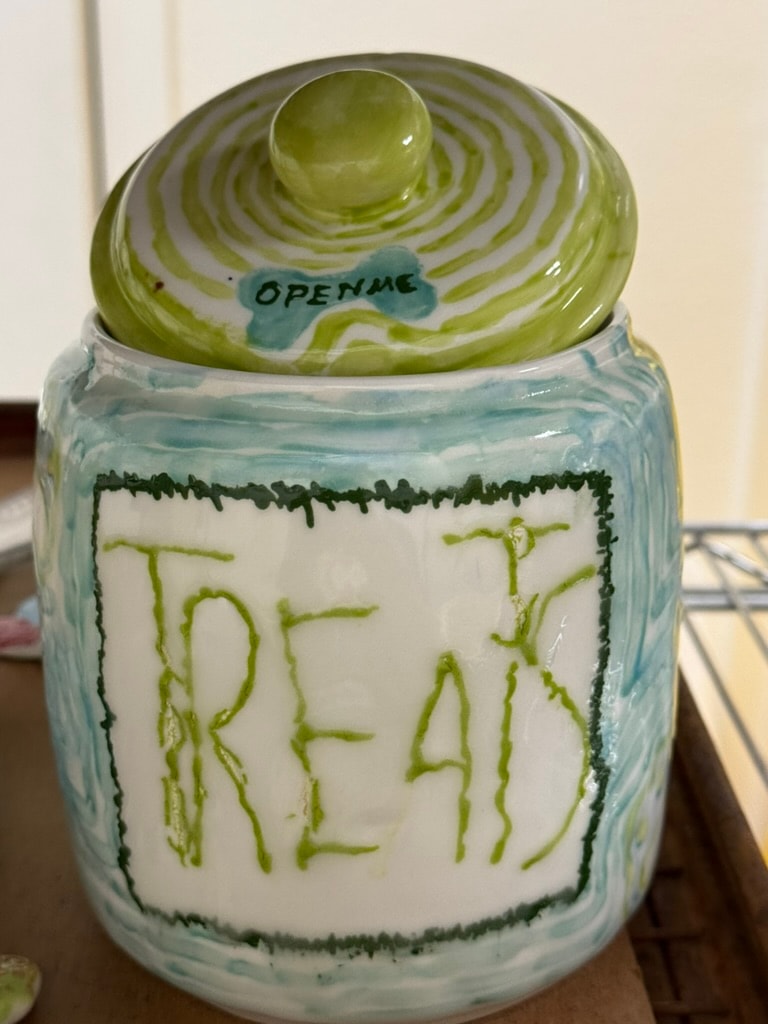 Ceramic jar labeled treat with green lid